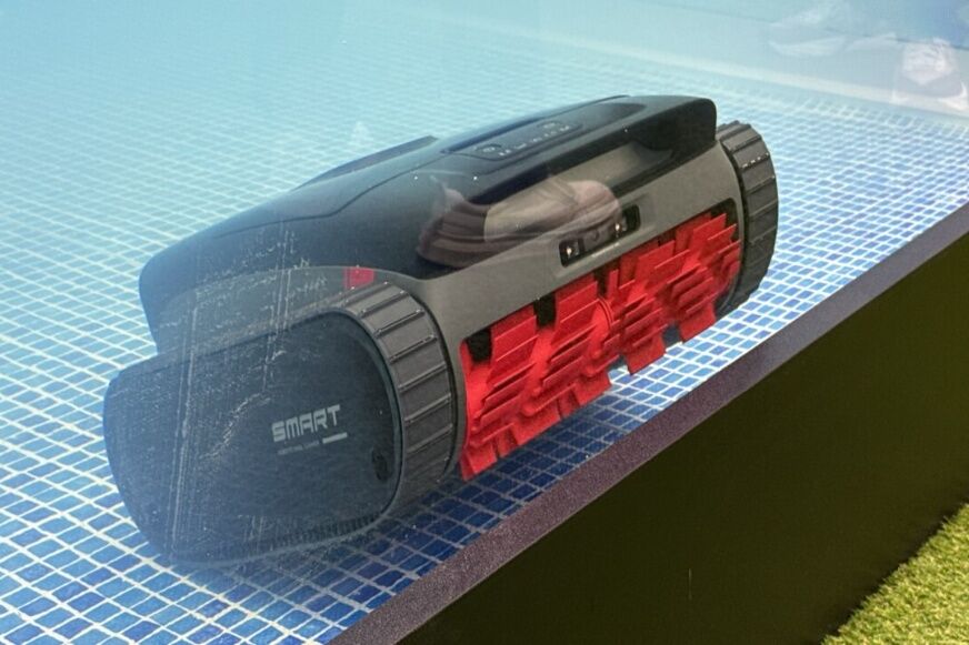Roborock RockAqua P1 reinigt eine flache Poolstufe nahe einem Wasserspiel